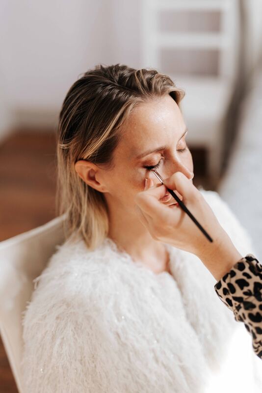 Maquillage des yeux d’une mariée en étole de fourrure blanche.