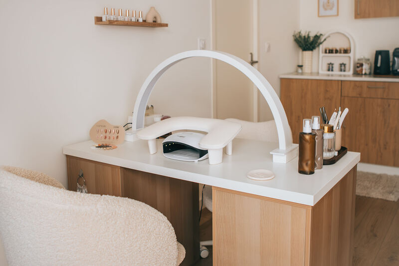 Le poste de manucure du salon, sa lampe en arche et ses flacons.