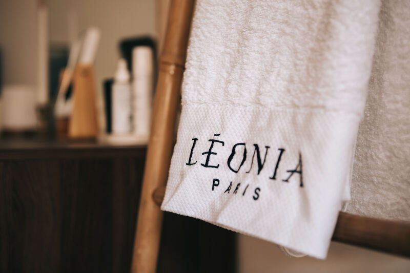 Une serviette brodée Léonia Paris, posée dans la cabine de soin.